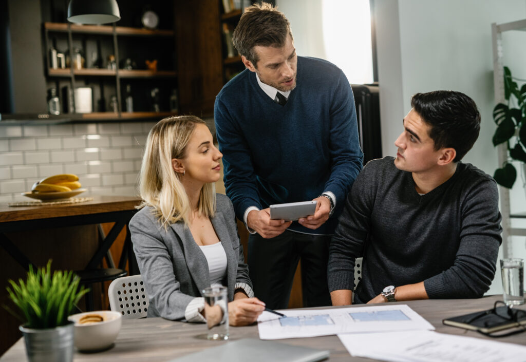young renters sign a lease agreement with the property manager in an apartment